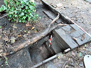 A brick foundation tucked under the kerb of the path