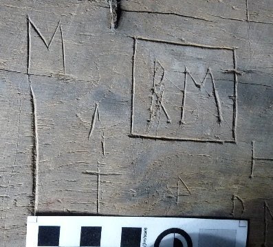 Engraved letters ‘M T’ – with serifs
