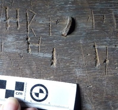 Array of faintly scratched marks including an inverted V and 3 Double-V shapes